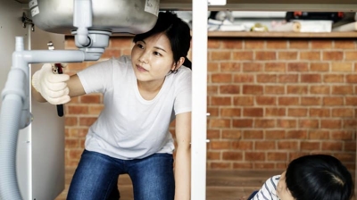 3 Reasons Why My Pipes Are Always Rattling A woman is repairing a water pipe.