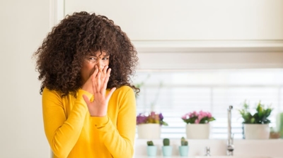 Why Does My Air Conditioner Smell So Bad? A woman covered her nose.