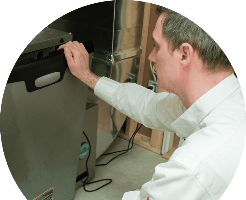 Knight HVAC professional installing a new furnace unit, aligning the front panel with surrounding ductwork and wiring in a residential utility space.