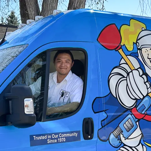 knight_about Knight Plumbing technician standing by our famous green trucks in a residential neighbourhood.