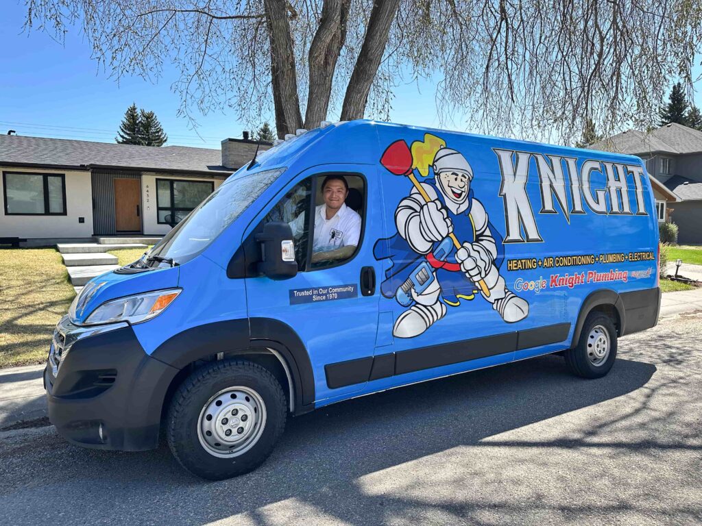 Knight Plumbing, Heating, Air Conditioning & Electrical blue service van with a smiling technician in the driver’s seat on a residential street.